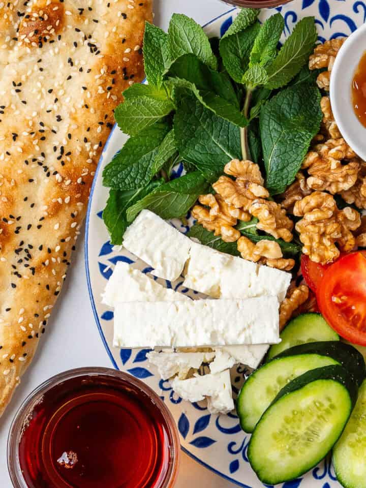 Persian Breakfast served on a plate with barbari bread and tea on the side