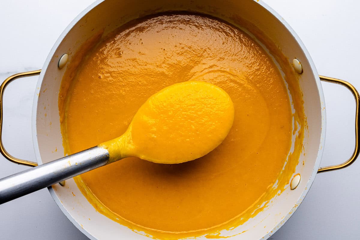 Ladle spoon in a large pot of carrot soup