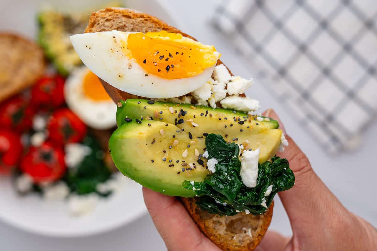 Close up of egg, avocado and spinach with feta on a piece of toast