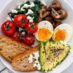 Breakfast bowl with eggs, avocado, toast, mushrooms, spinach and feta and tomatoes