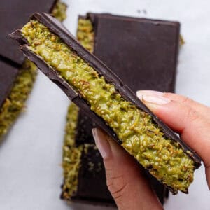 Piece of Dubai Chocolate held up showing the pistachio filling