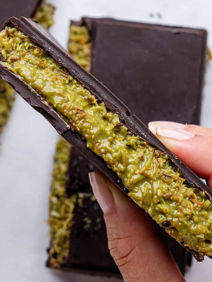 Piece of Dubai Chocolate held up showing the pistachio filling