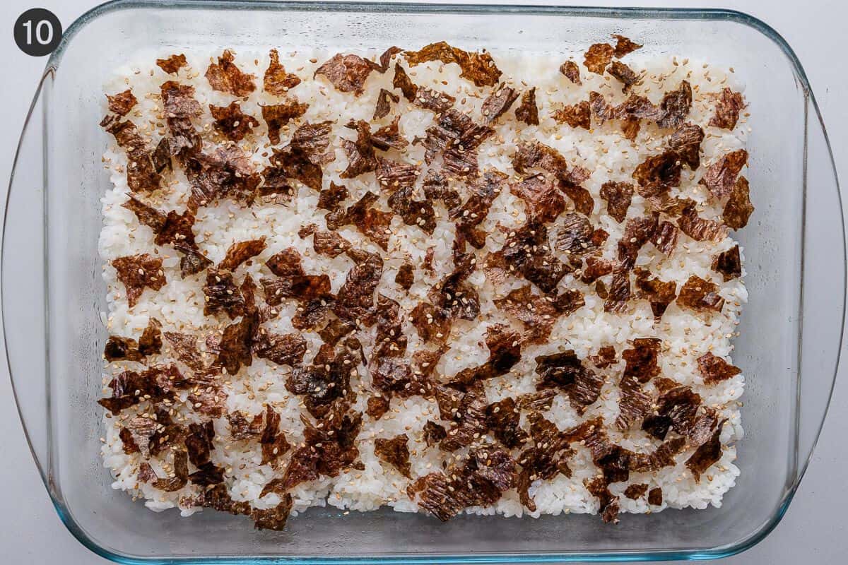 Seaweed and sesame seeds added on top of rice layer