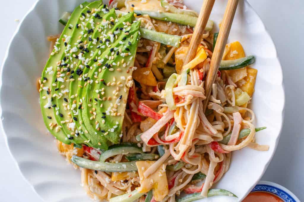 Kani salad topped with avocado and panko breadcrumbs with chopsticks