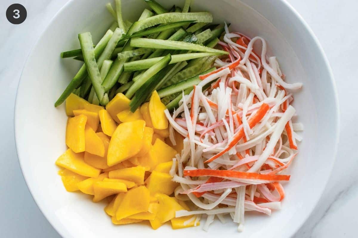 Prepared cucumber, surimi and mango in a bowl