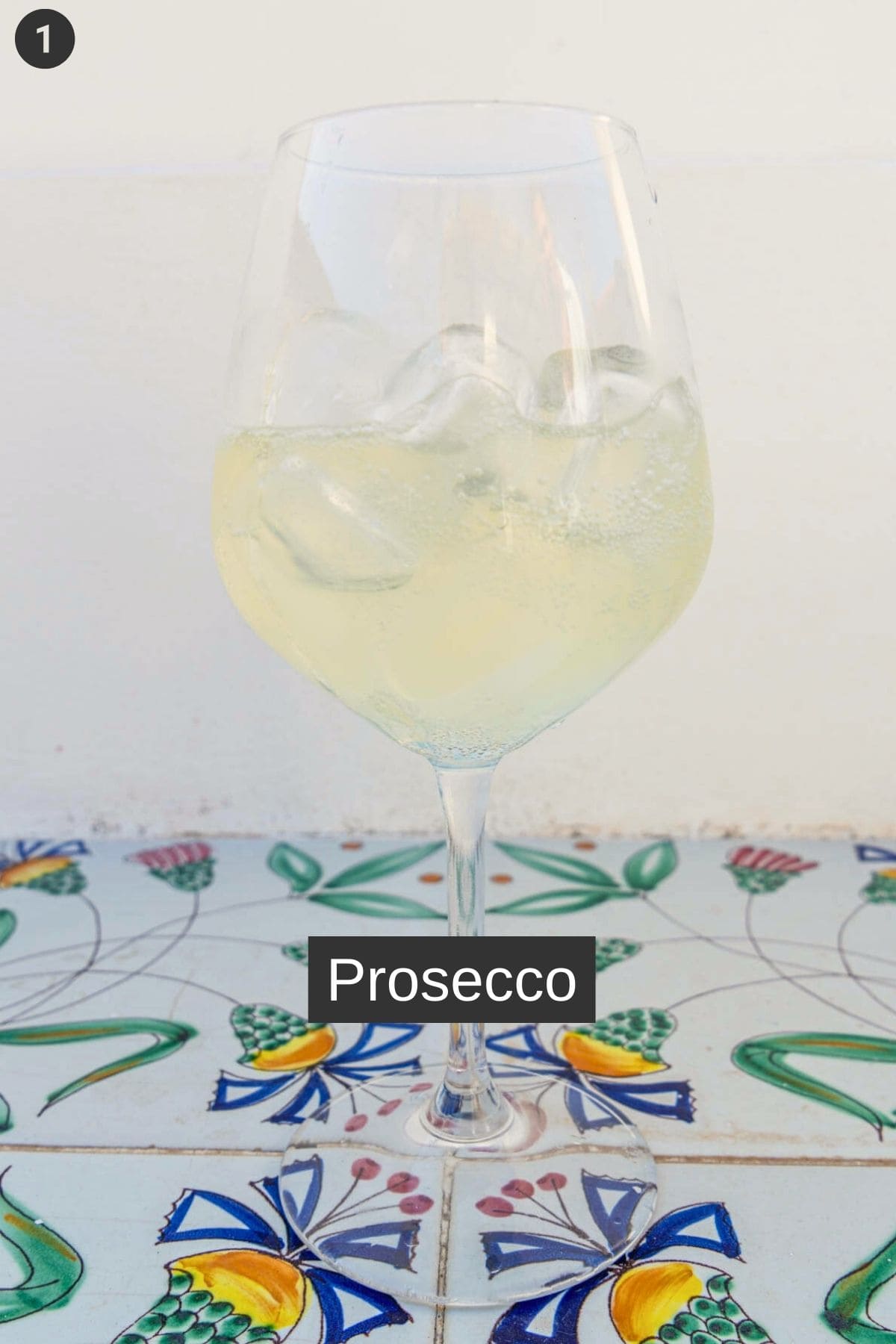 Prosecco being added to a glass of ice to make limoncello spritz