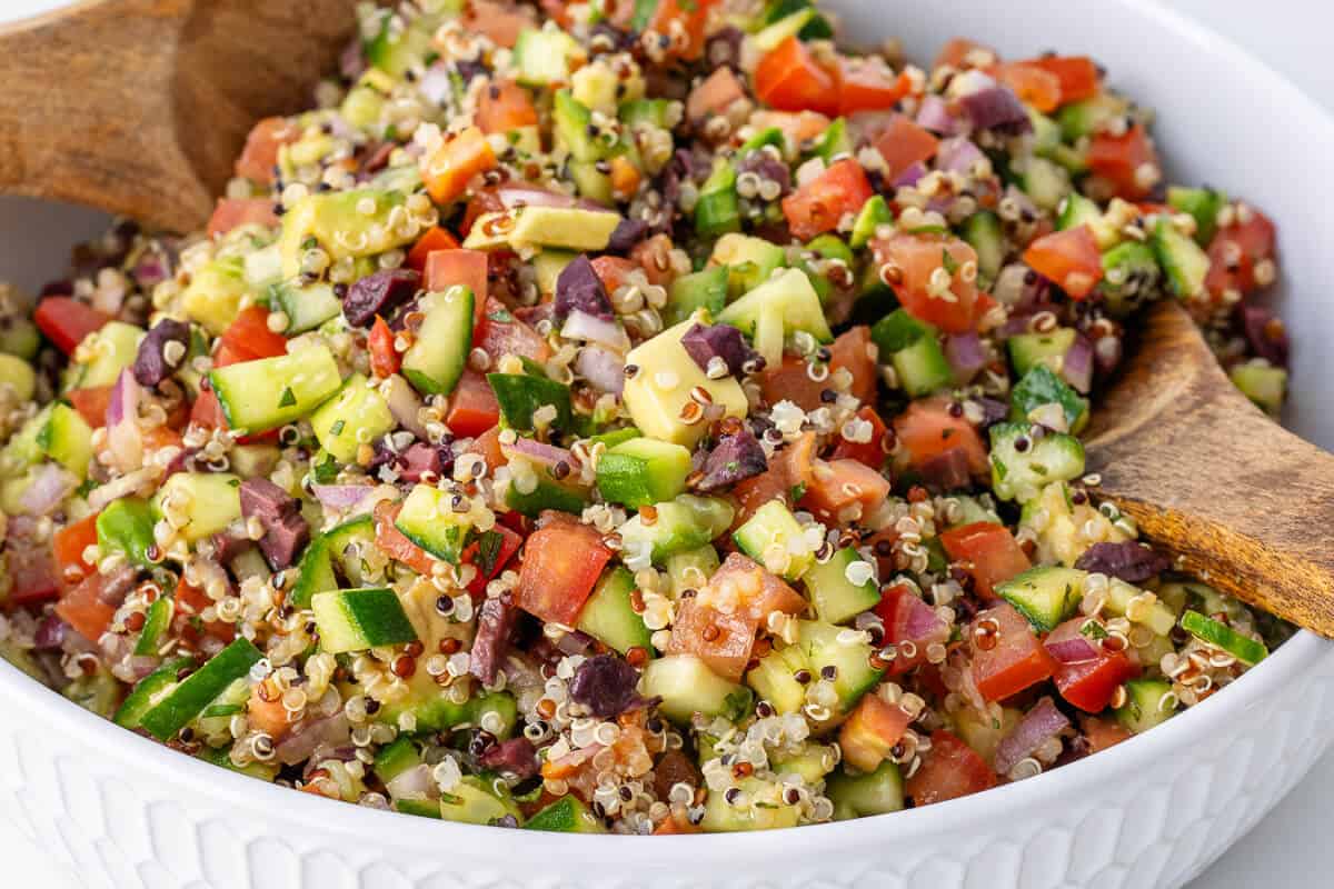 Quinoa salad in a bowl with wooden spoons
