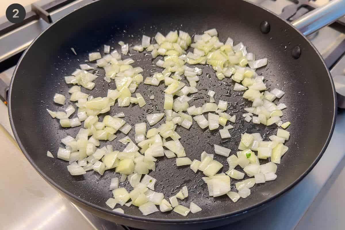 Onions being sautéed in a pan