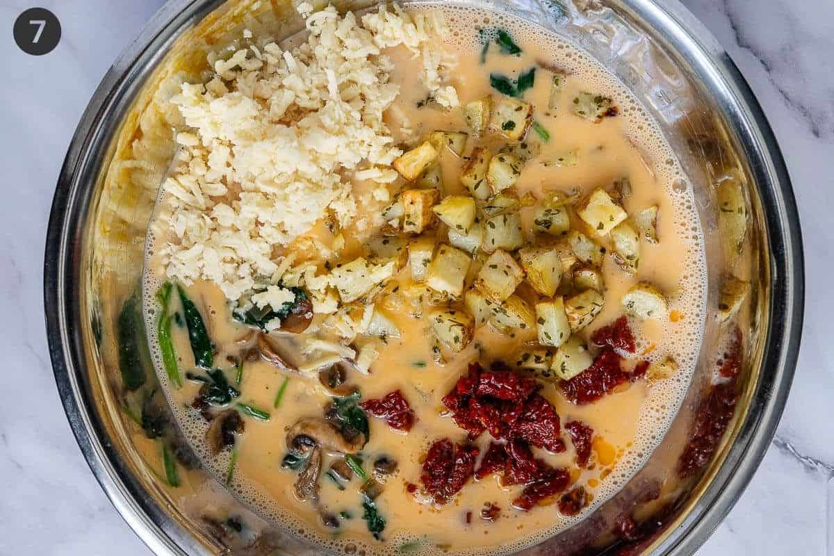 Veggies, cheese and eggs in a large bowl before being mixed