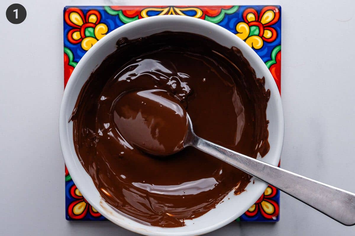 Chocolate melted in a bowl with a teaspoon