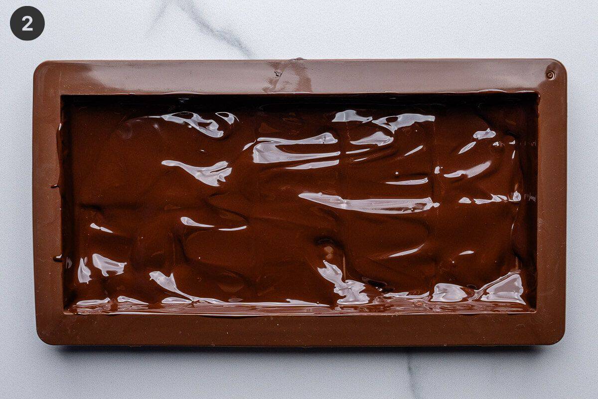 Layer of melted chocolate added to mold and spread evenly