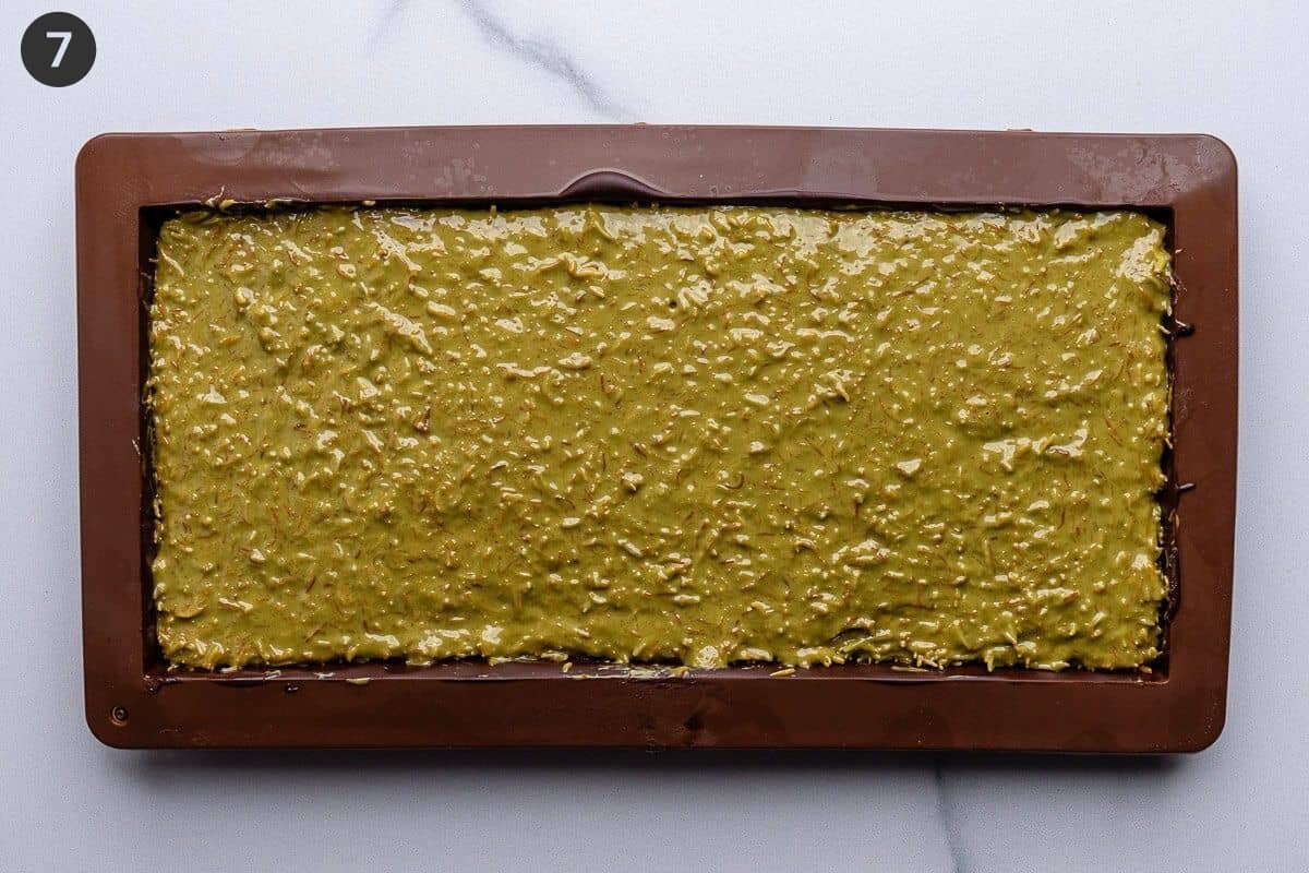 Pistachio mixture added to the mold and spread evenly