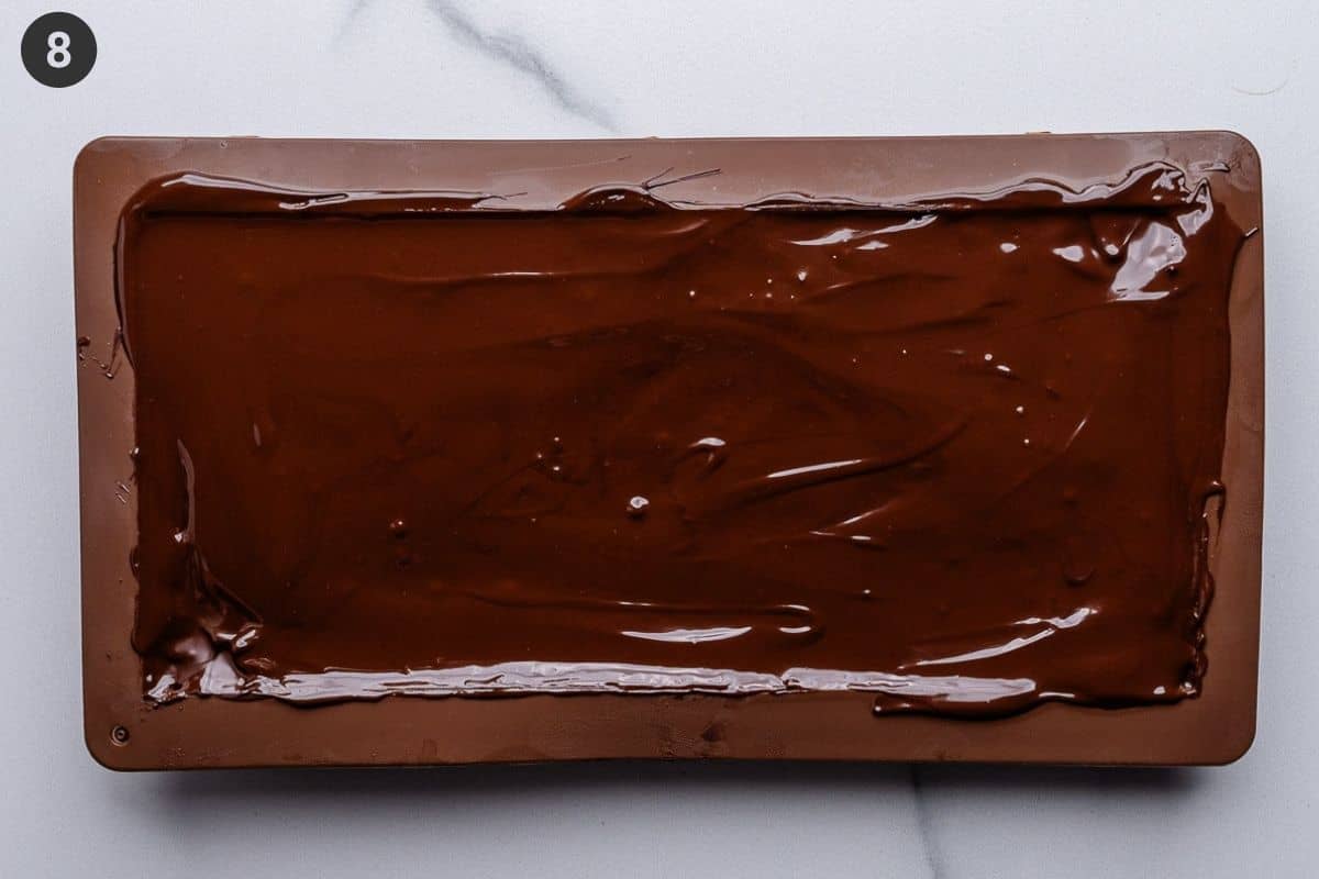 Final top layer of melted chocolate added to the mold and spread evenly