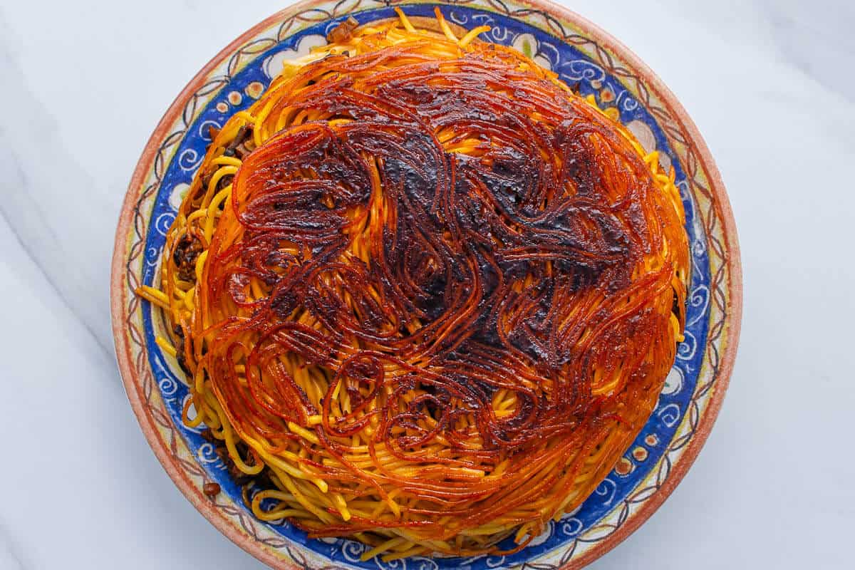 Makaroni Persian spaghetti flipped upside down with a crispy tahdig on a large plate