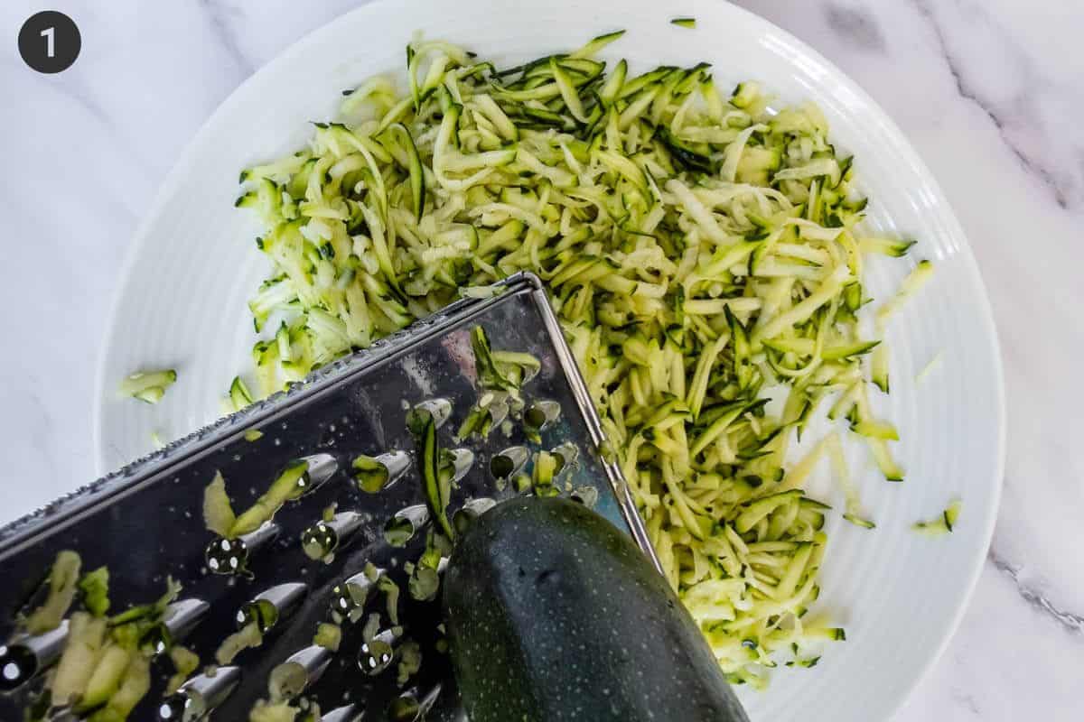 Zucchini being grated on plate