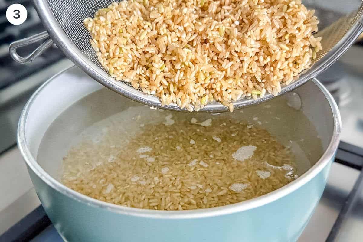 Brown rice being added to a pot of boiling water