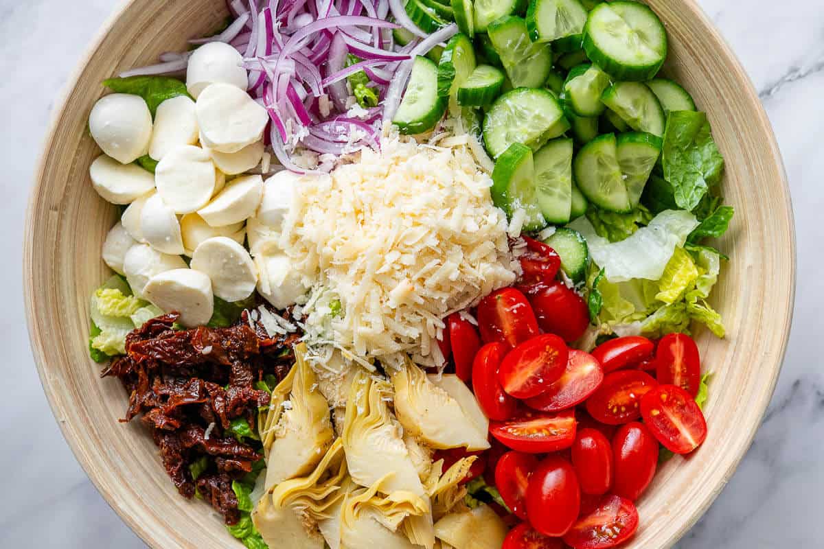 Salad ingredients in separate sections in a large bowl
