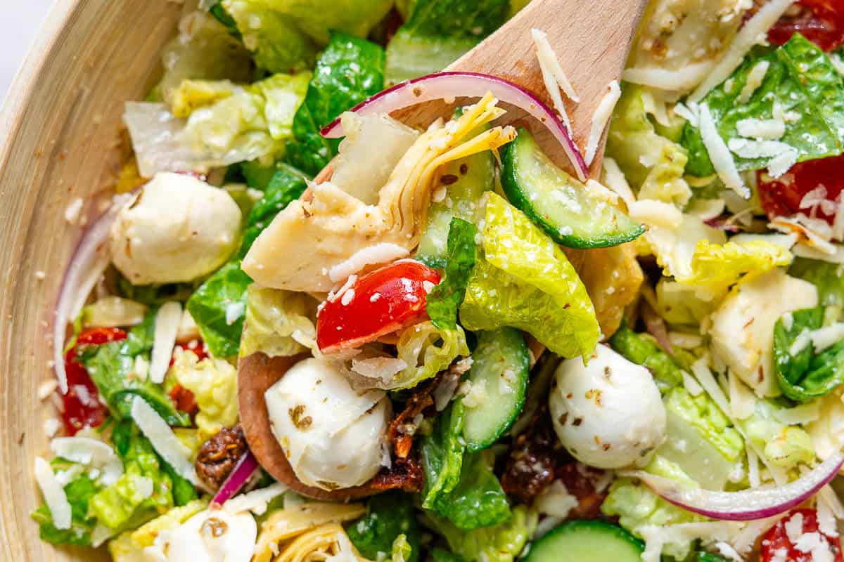Wooden spoon coming out of Italian Chopped Salad bowl