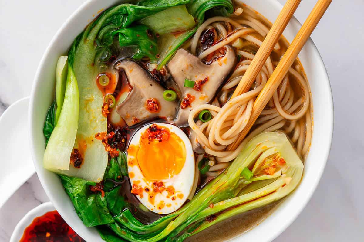 Bowl of Bokchoy Soup with chopsticks grabbing noodles