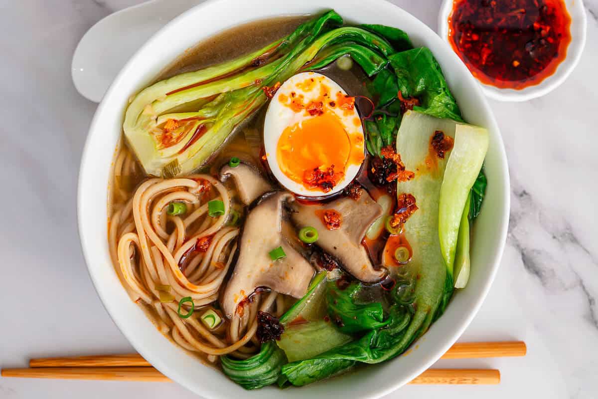 Bowl of soup with boychoy, mushrooms, noodles and a soft boiled egg