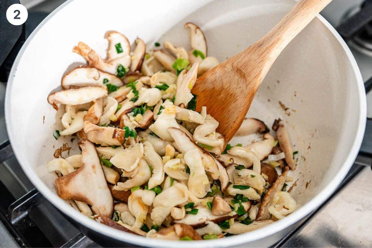 Sliced mushrooms added to the pot and being sautéed