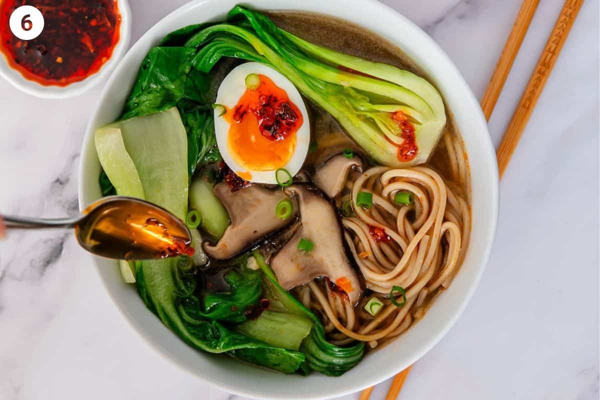 Final bokshoy soup served in a bowl, topped with a soft boiled egg and chilli oil