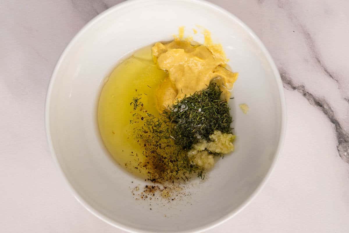 Dijon dressing ingredients added to a small bowl