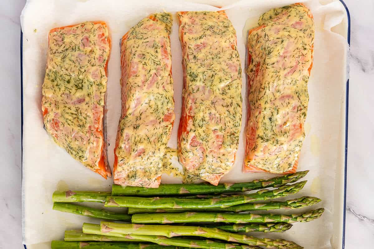 Asparagus added to the side of the oven dish with the salmon fillets just before baking