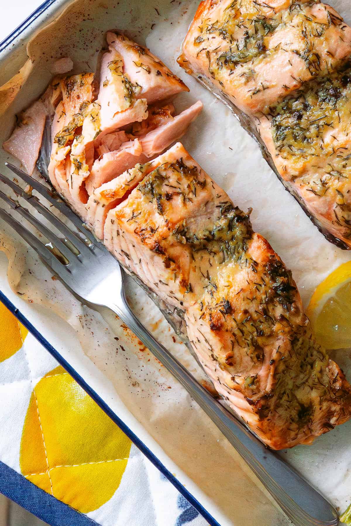 Close up of a piece of dijon salmon which has been flaked with a fork
