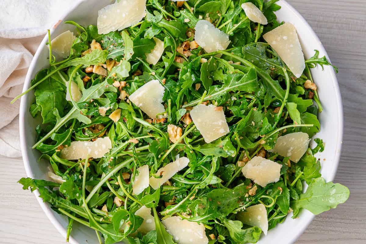 Bowl of arugula salad with parmesan and walnuts