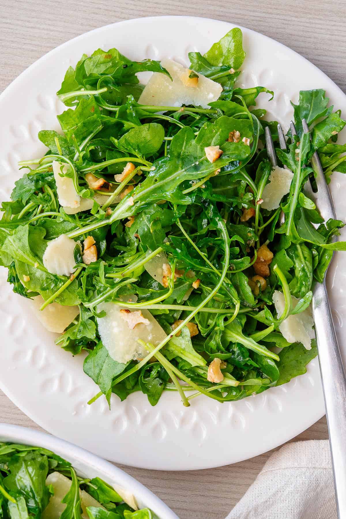 Arugula salad served on a plate with a fork