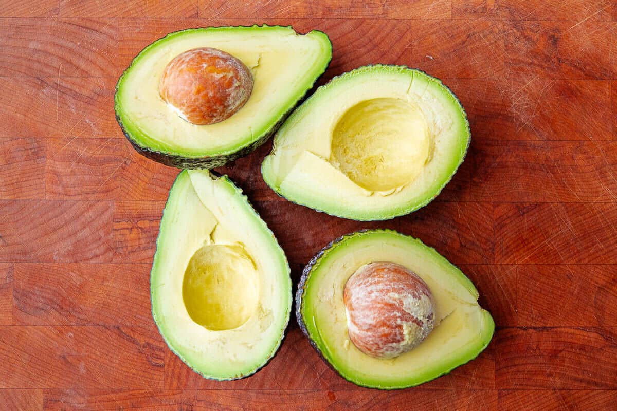 Two avocados sliced in half to show the inside