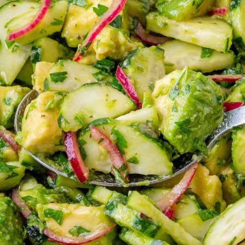 Close of up spoon full of Avocado Salad in a bowl