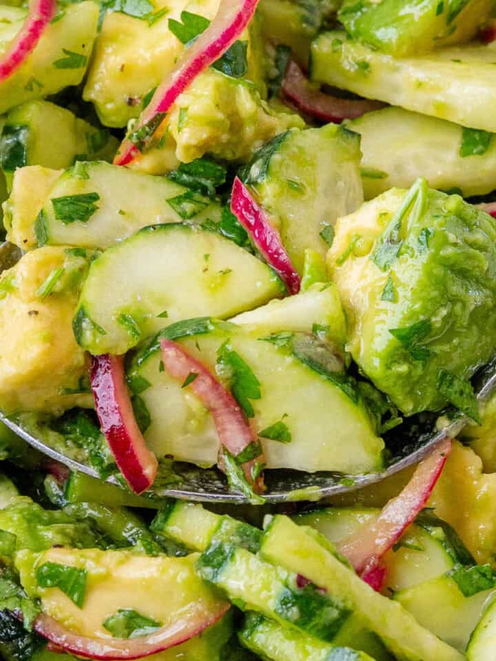 Close of up spoon full of Avocado Salad in a bowl