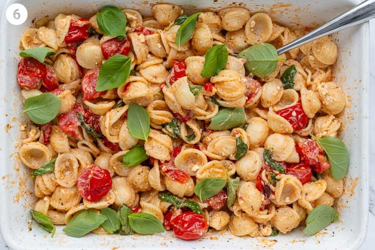 Pasta added to the baking dish and mixed all together then topped with fresh basil