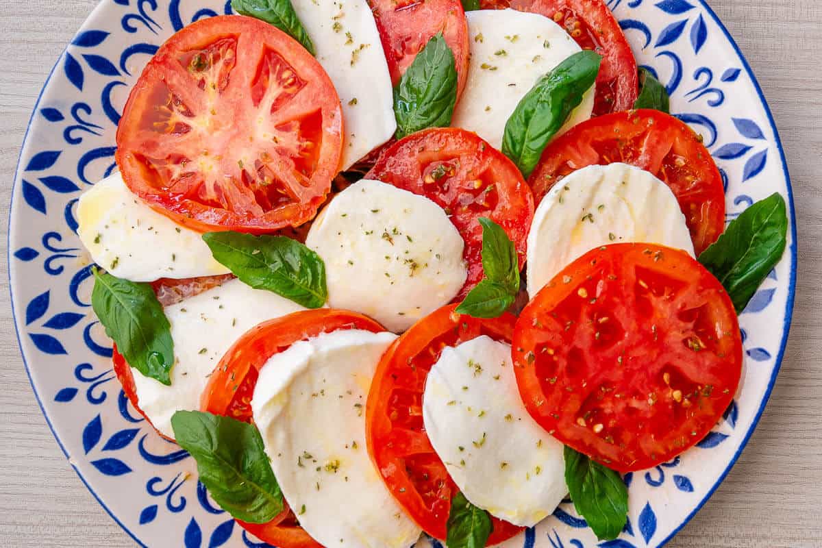 Plate of Caprese Salad with tomato, mozzarella and fresh basil