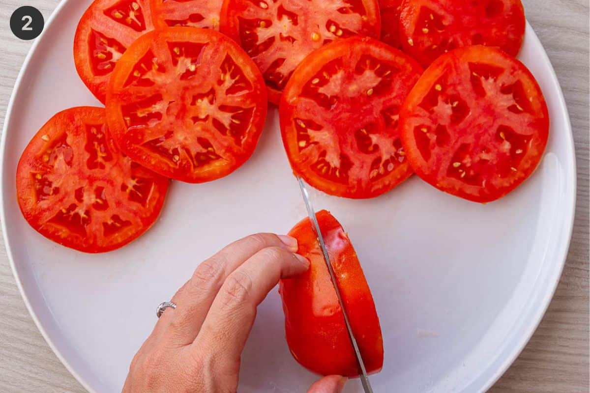 Tomato being sliced into thick pieces