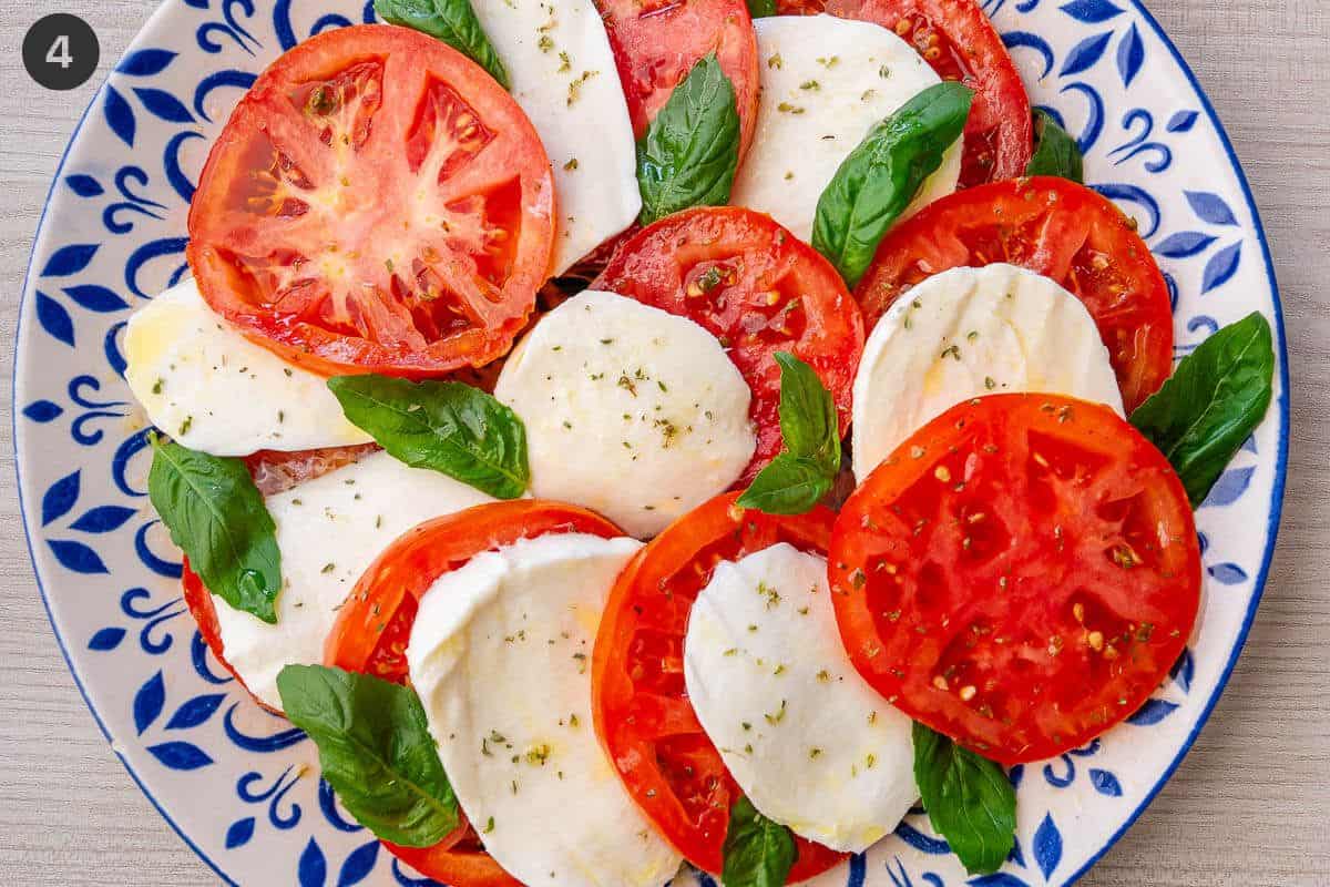 Fresh mozzrella added in between tomato slices and topped with fresh basil leaves