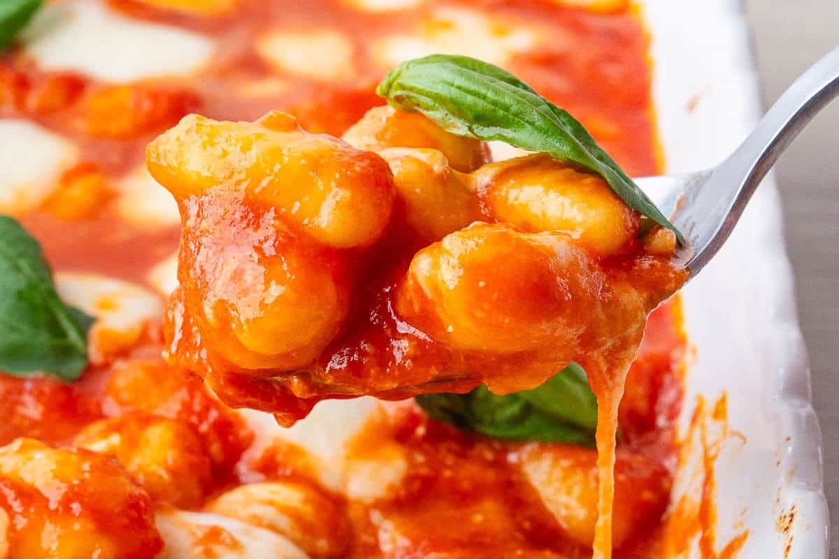 Spoon of Gnocchi alla Sorrentina coming out of the oven tray