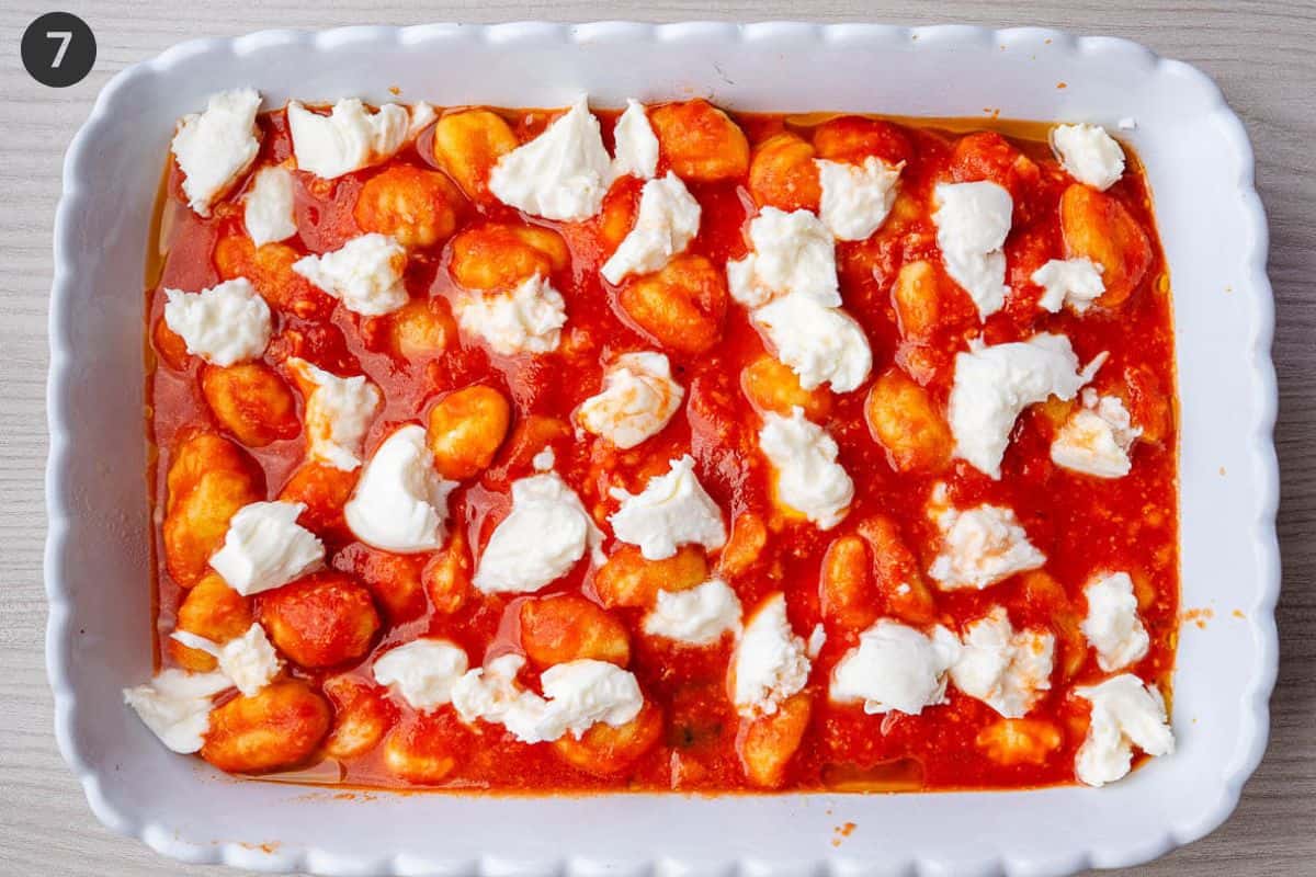 Gnocchi and tomato sauce added to an oven dish then topped with fresh mozzarella