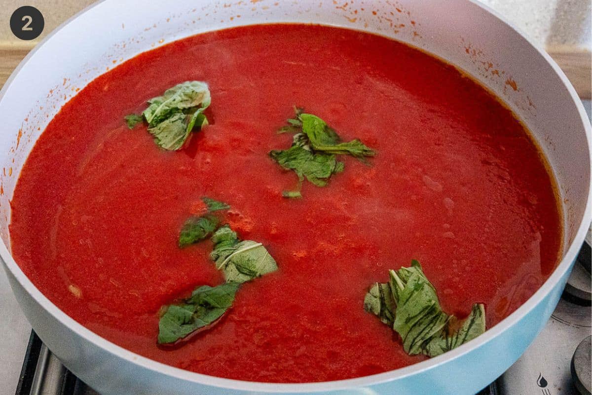 Tomato sauce added to pan with basil and seasoning
