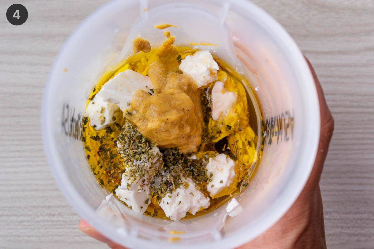 Feta dressing ingredients added to a cup, about to be blended