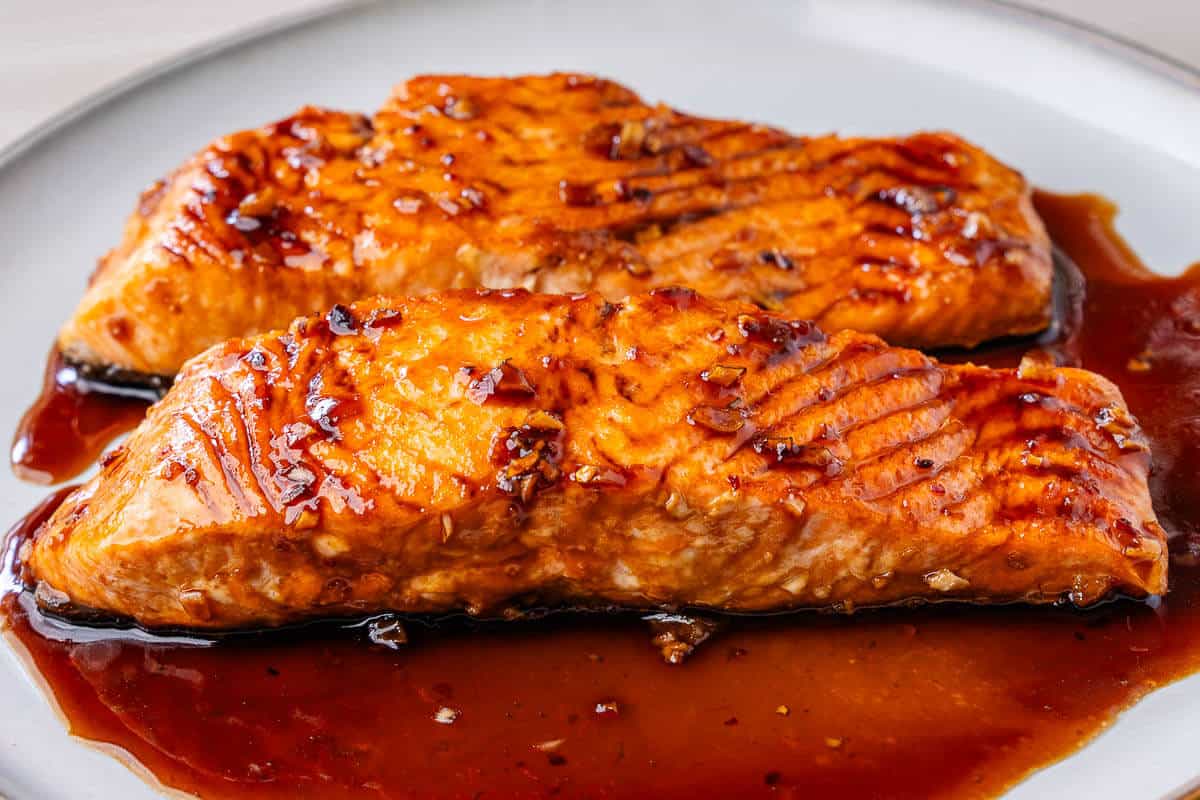 Honey garlic salmon fillets on a plate drizzled over with sauce