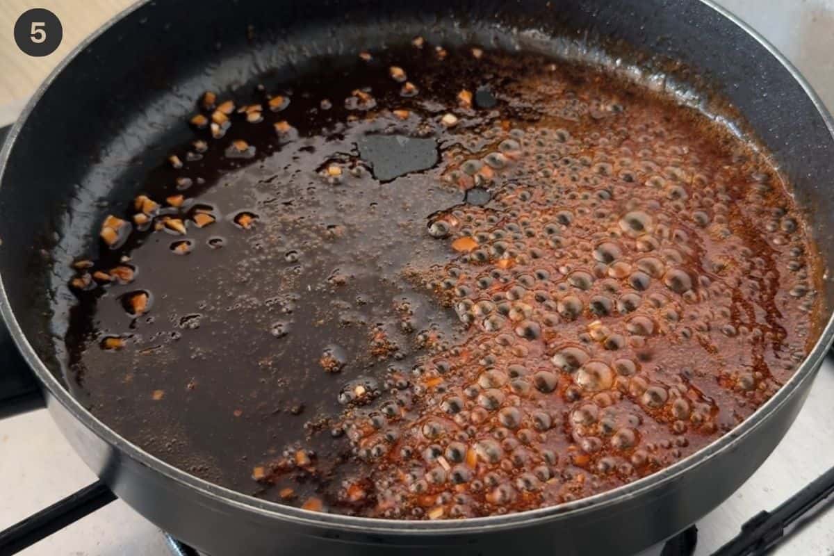 Salmon fillets removed from pan and sauce left to reduce and thicken