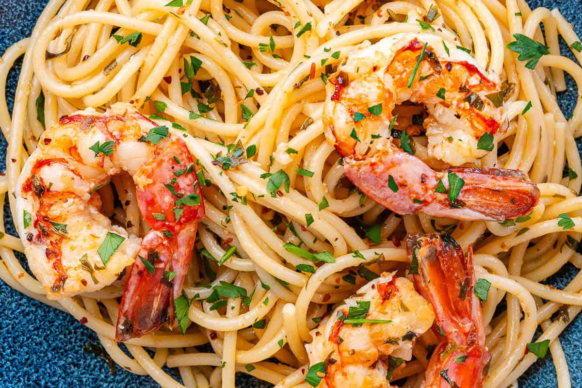 Shrimp pasta in a bowl topped with parsley and chili flakes