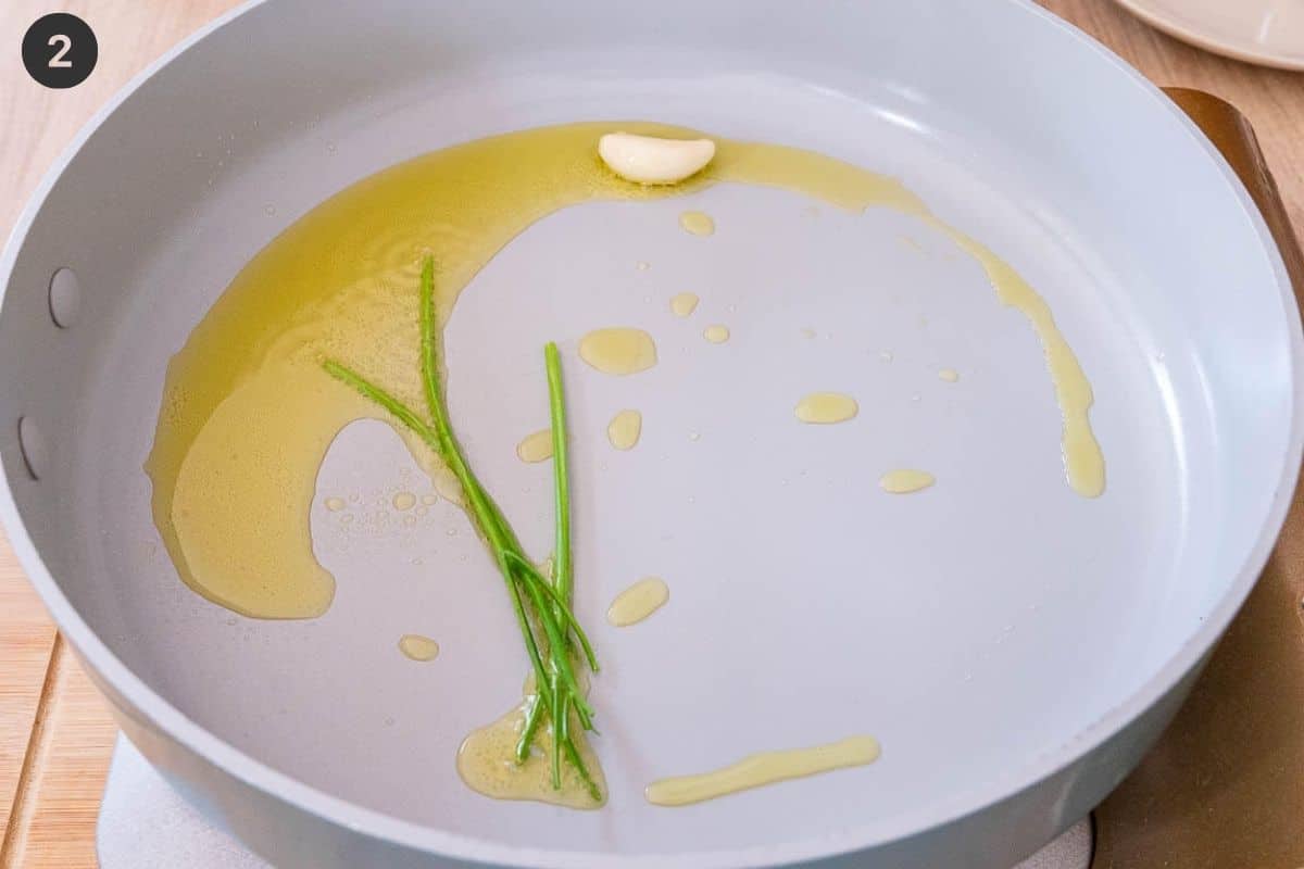 Oil and garlic being sautéed in a pan