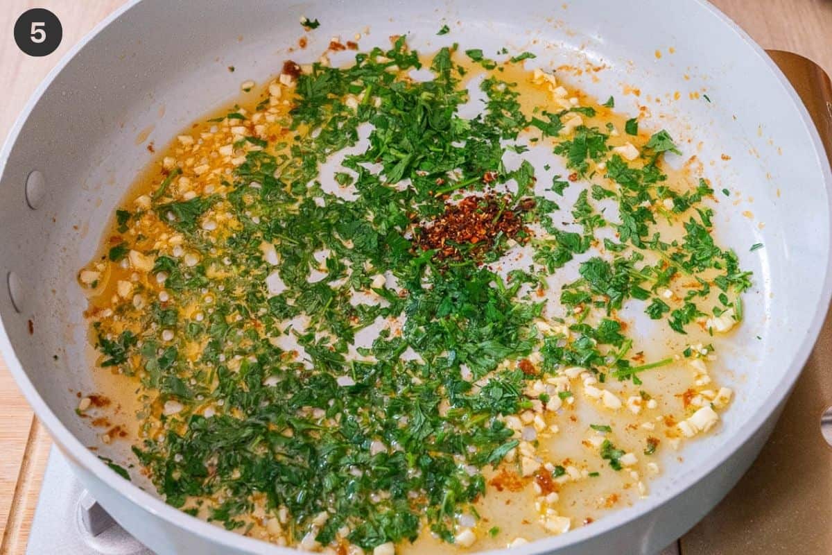 Parsley, garlic and red pepper flakes and oil added to the pan