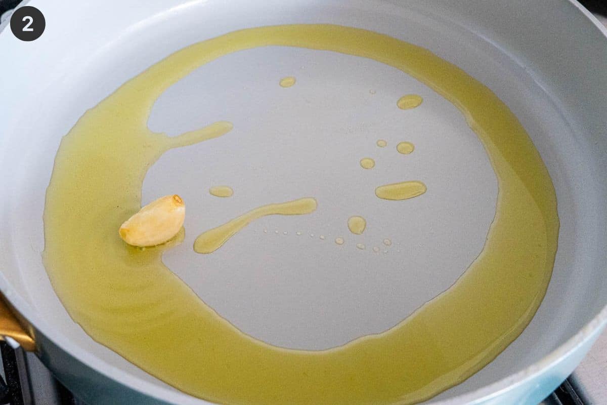 Garlic being sautéed in olive oil in a pan