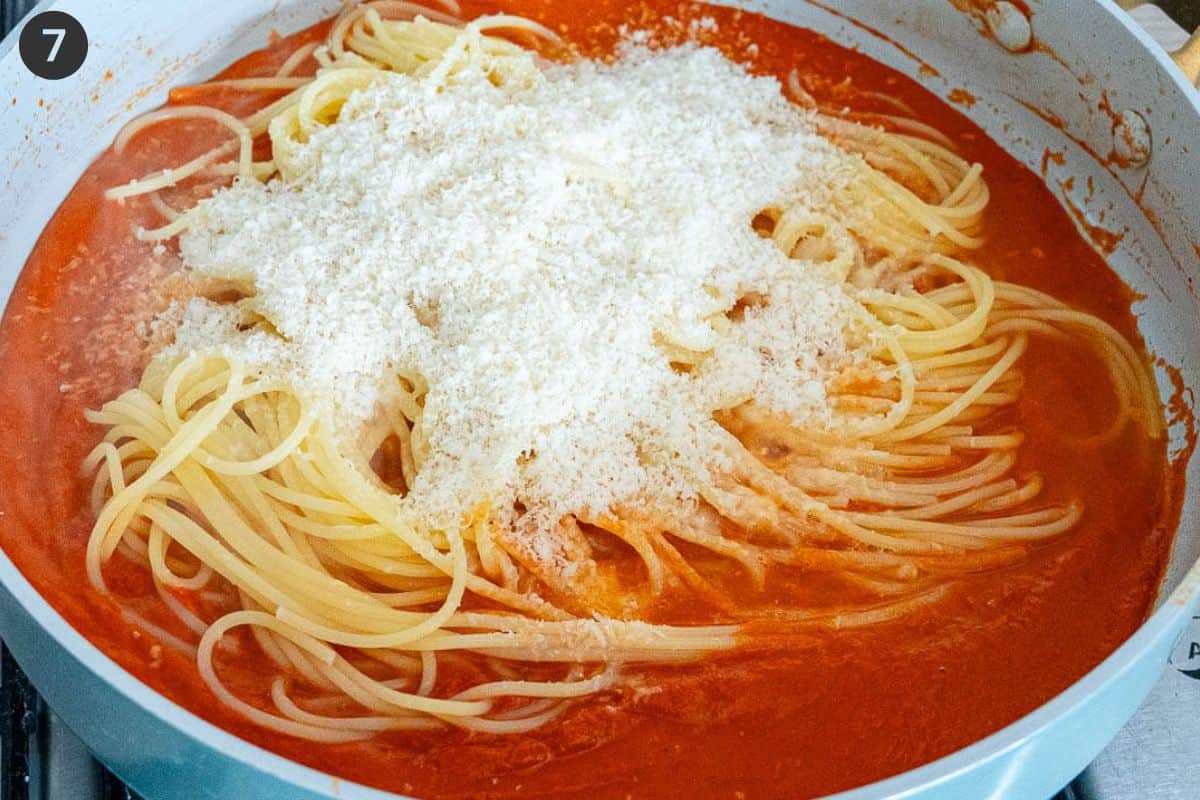 Cooked pasta and parmesan cheese added to the pan with pomodoro sauce