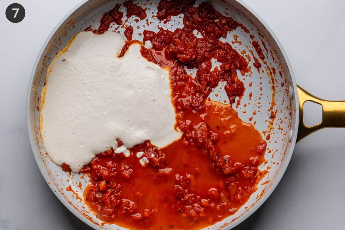 Cashew cream added to tomato sauce in pan